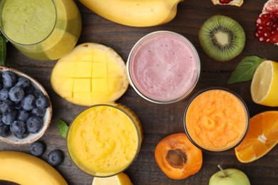 Photo of Tasty smoothies in glasses and ingredients on wooden table, flat lay