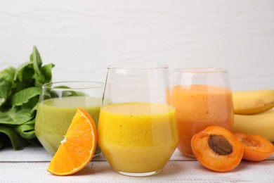 Photo of Tasty smoothies in glasses and ingredients on wooden rustic table, closeup