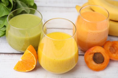 Photo of Tasty smoothies in glasses and ingredients on wooden rustic table, closeup