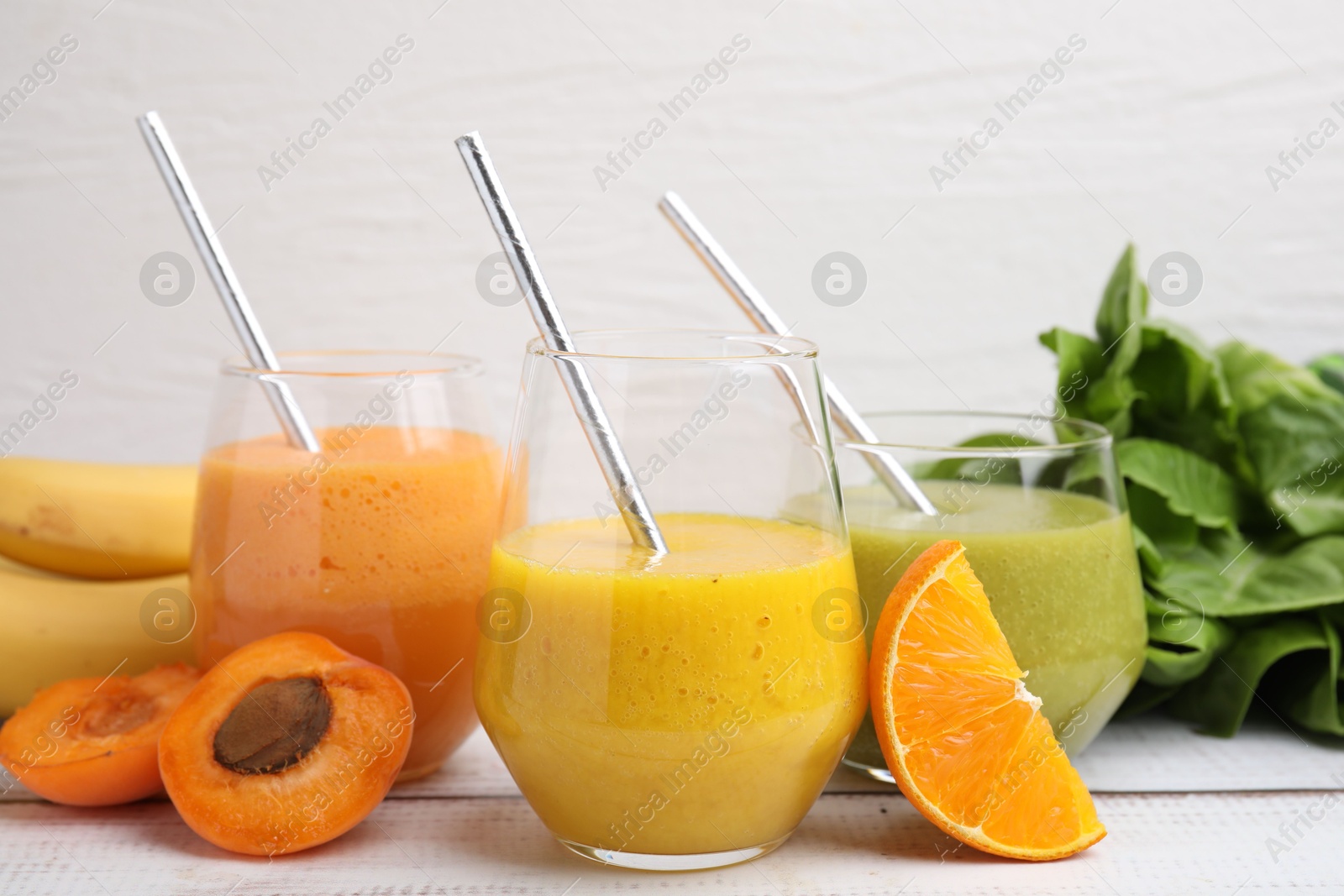 Photo of Tasty smoothies in glasses and ingredients on wooden rustic table, closeup