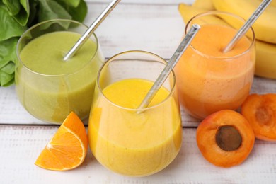 Photo of Tasty smoothies in glasses and ingredients on wooden rustic table, closeup