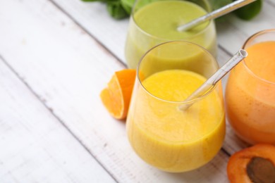 Photo of Tasty smoothies in glasses and ingredients on wooden rustic table, closeup. Space for text