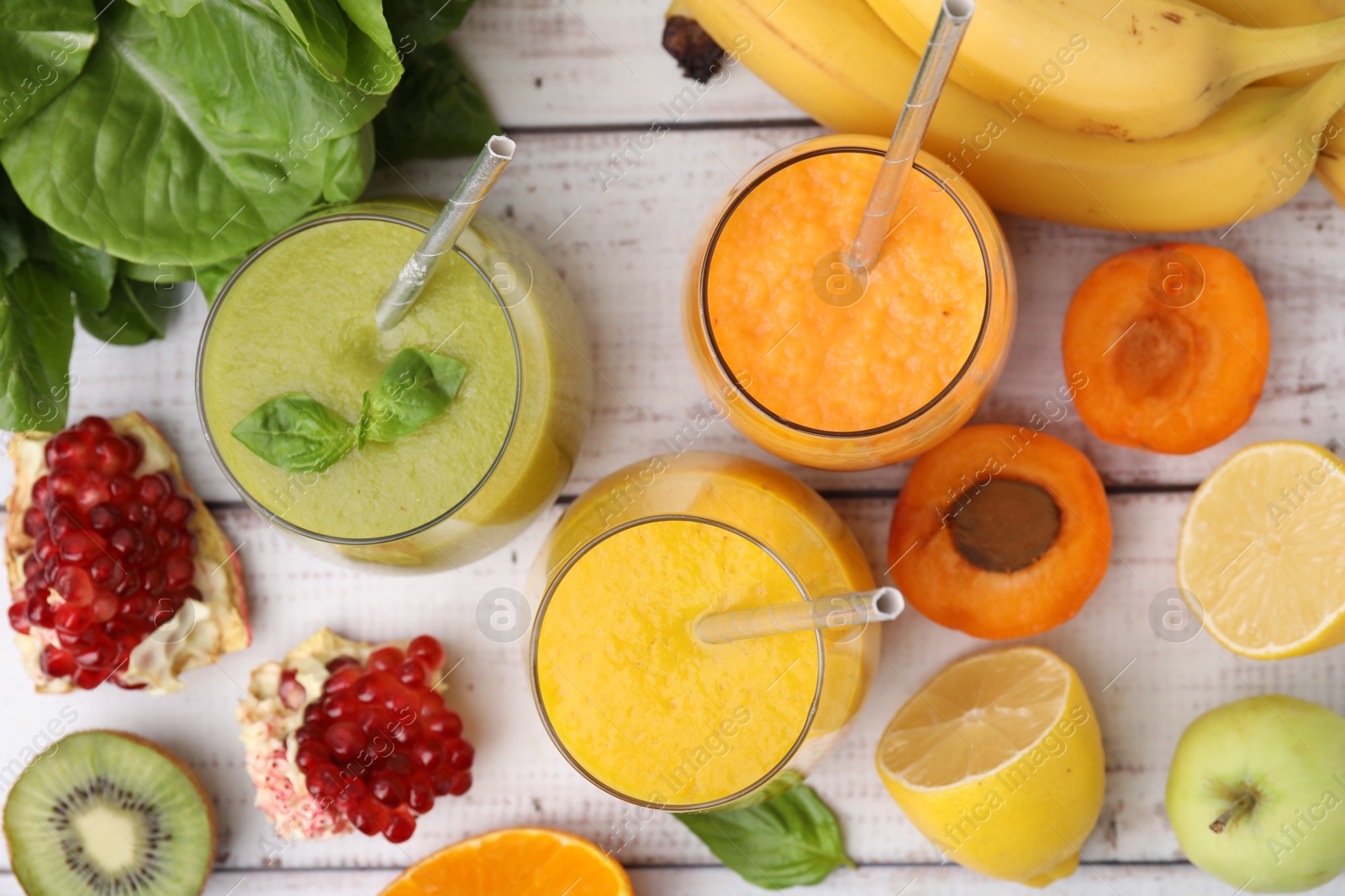 Photo of Tasty smoothies in glasses and ingredients on wooden rustic table, flat lay