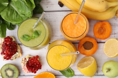 Tasty smoothies in glasses and ingredients on wooden rustic table, flat lay