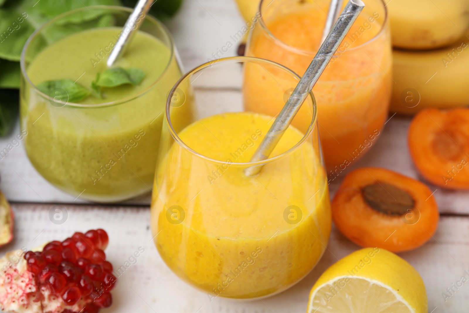 Photo of Tasty smoothies in glasses and ingredients on wooden rustic table, closeup