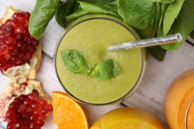 Tasty green smoothie in glass and products on wooden rustic table, flat lay