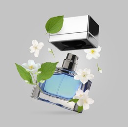 Image of Bottle of floral perfume and jasmine flowers in air on light grey background