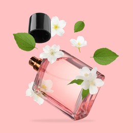 Image of Bottle of floral perfume and jasmine flowers in air on pink background