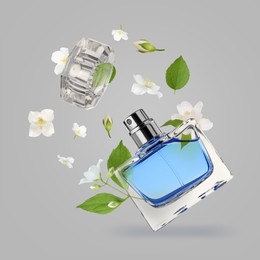 Image of Bottle of floral perfume and jasmine flowers in air on grey background