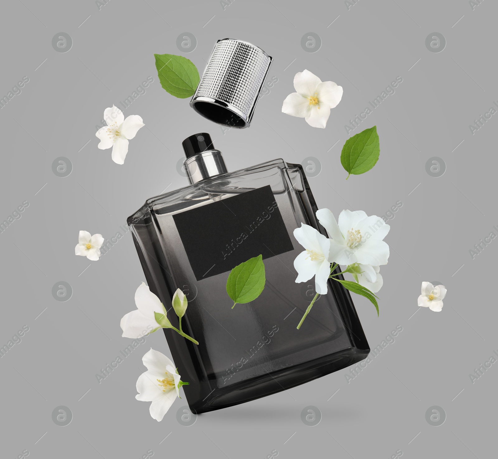 Image of Bottle of floral perfume and jasmine flowers in air on grey background