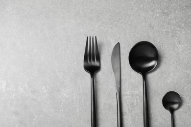 Photo of Stylish cutlery on grey table, flat lay. Space for text