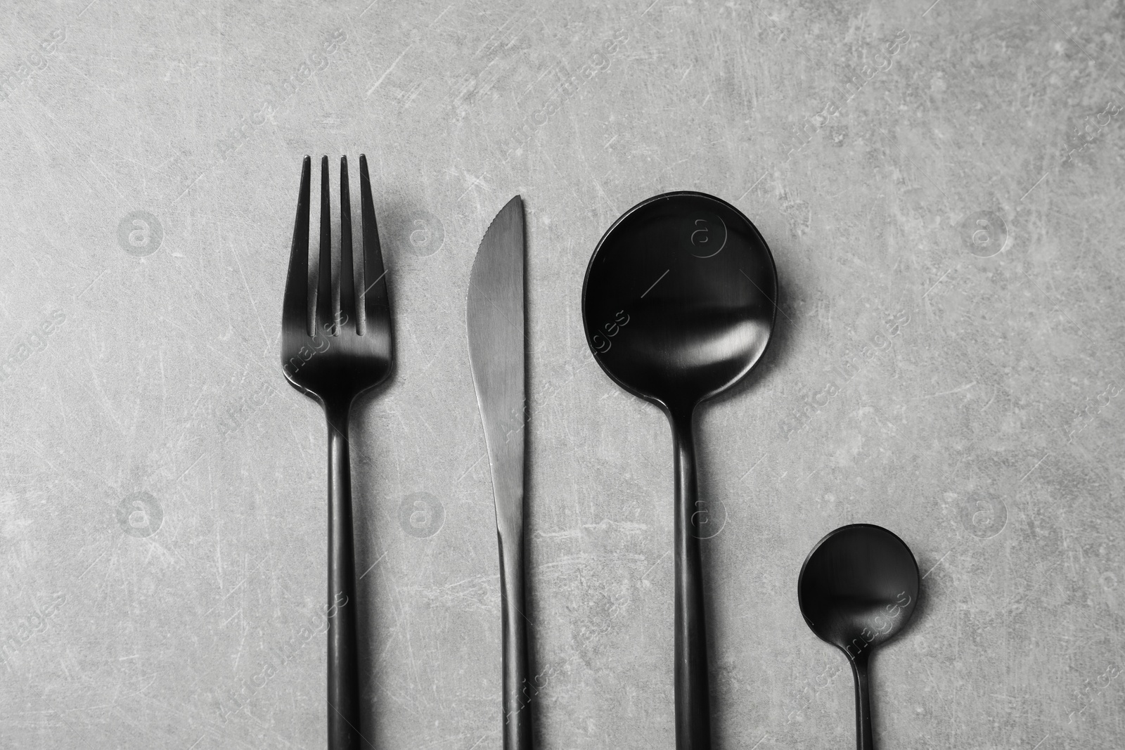 Photo of Stylish cutlery on grey table, flat lay