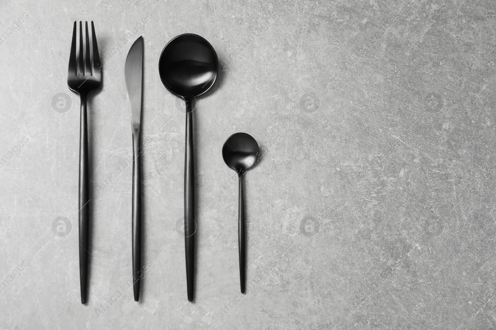 Photo of Stylish cutlery on grey table, flat lay. Space for text