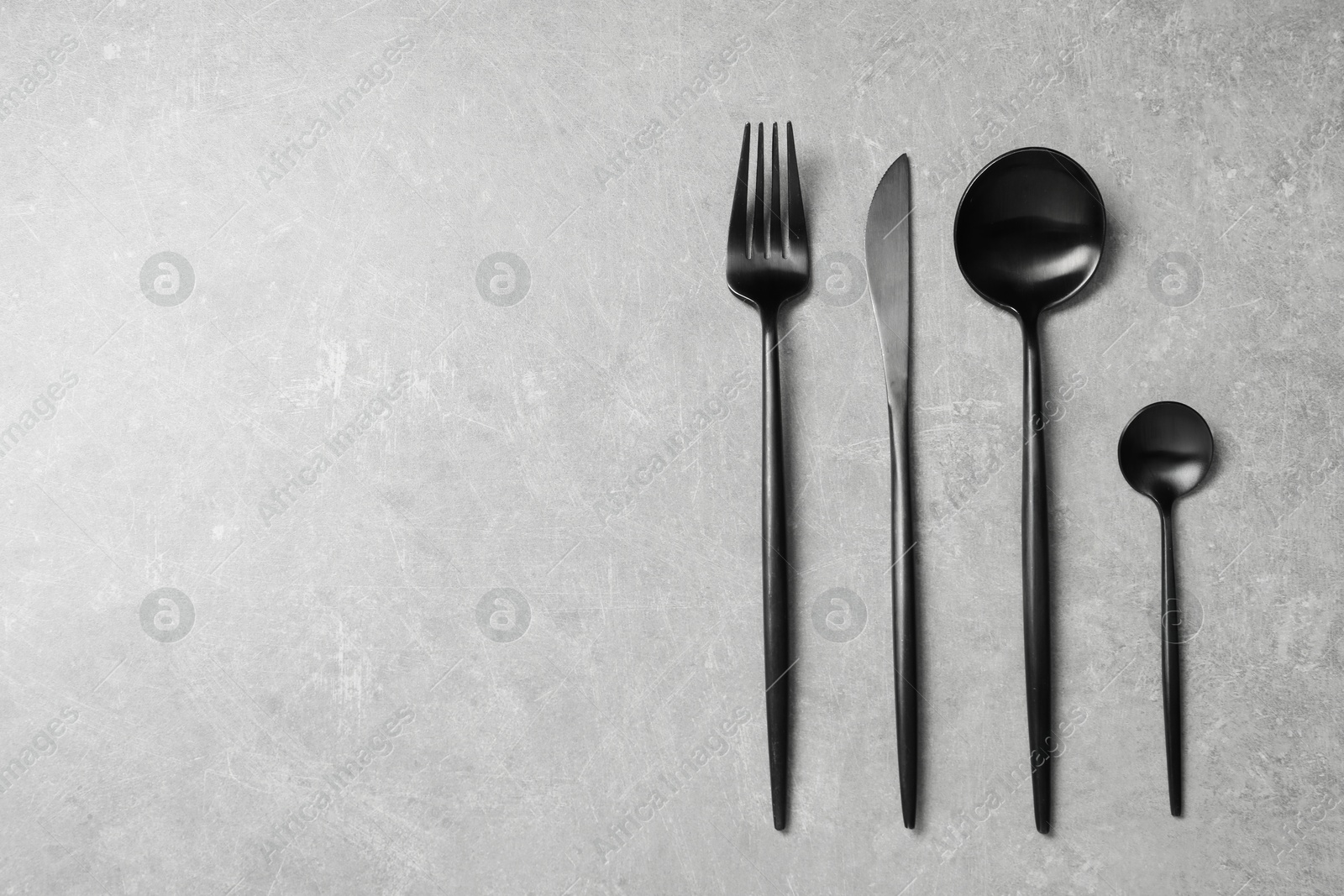 Photo of Stylish cutlery on grey table, flat lay. Space for text