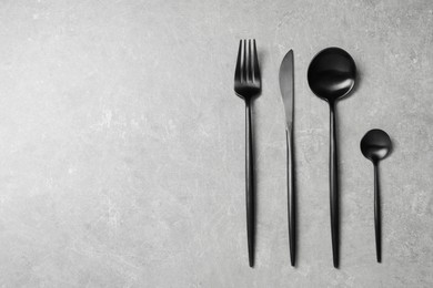 Photo of Stylish cutlery on grey table, flat lay. Space for text