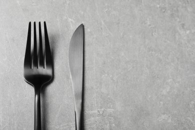 Photo of Stylish cutlery on grey table, top view. Space for text