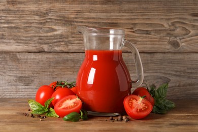 Photo of Tasty tomato juice in glass jug, fresh vegetables and spices on wooden table