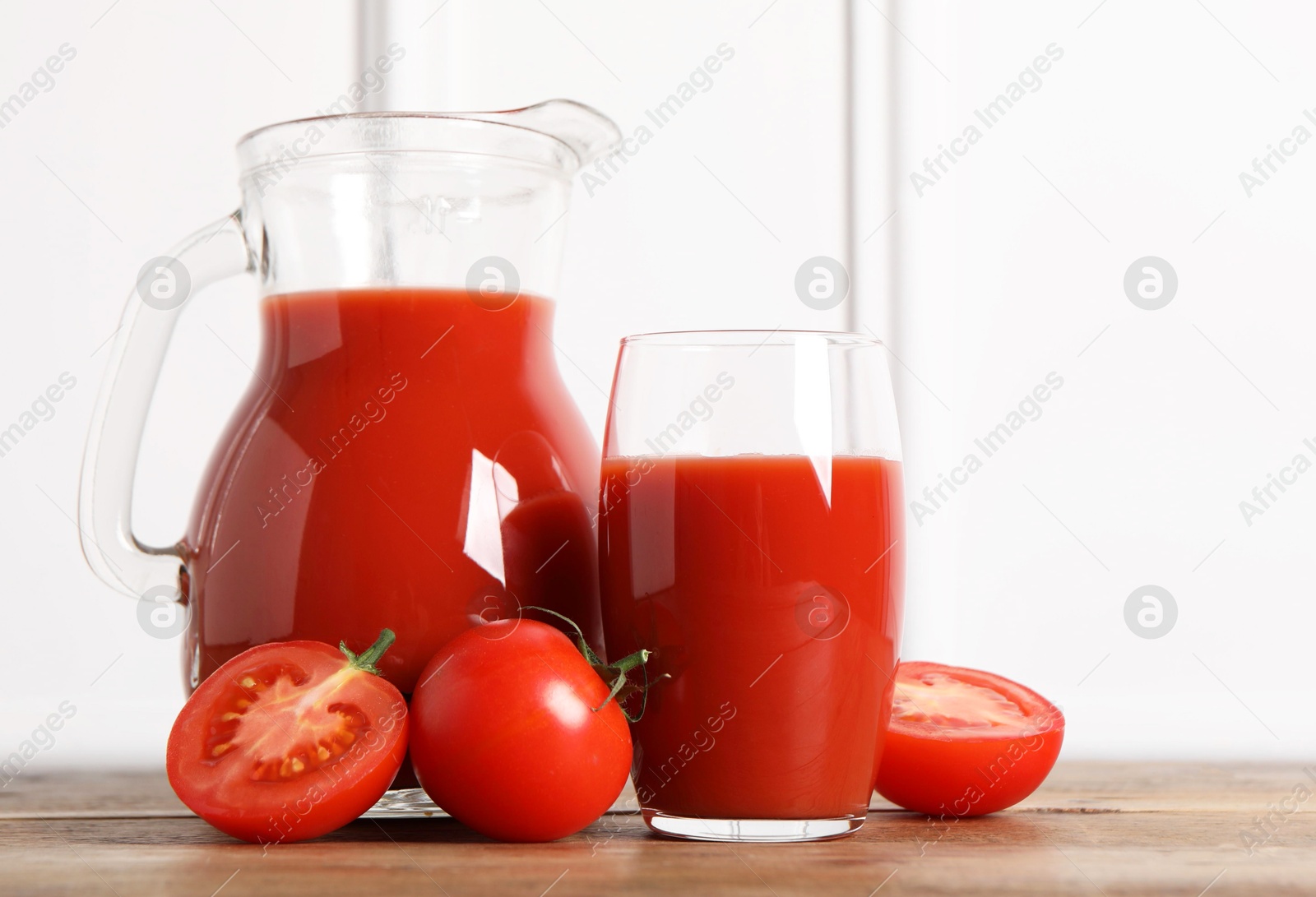 Photo of Tasty tomato juice and fresh vegetables on wooden table