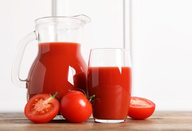 Photo of Tasty tomato juice and fresh vegetables on wooden table