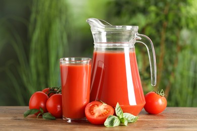 Photo of Tasty tomato juice, basil and fresh vegetables on wooden table outdoors