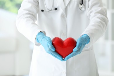 Doctor with red heart in clinic, closeup