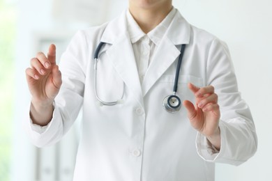 Photo of Doctor with stethoscope holding something in clinic, closeup