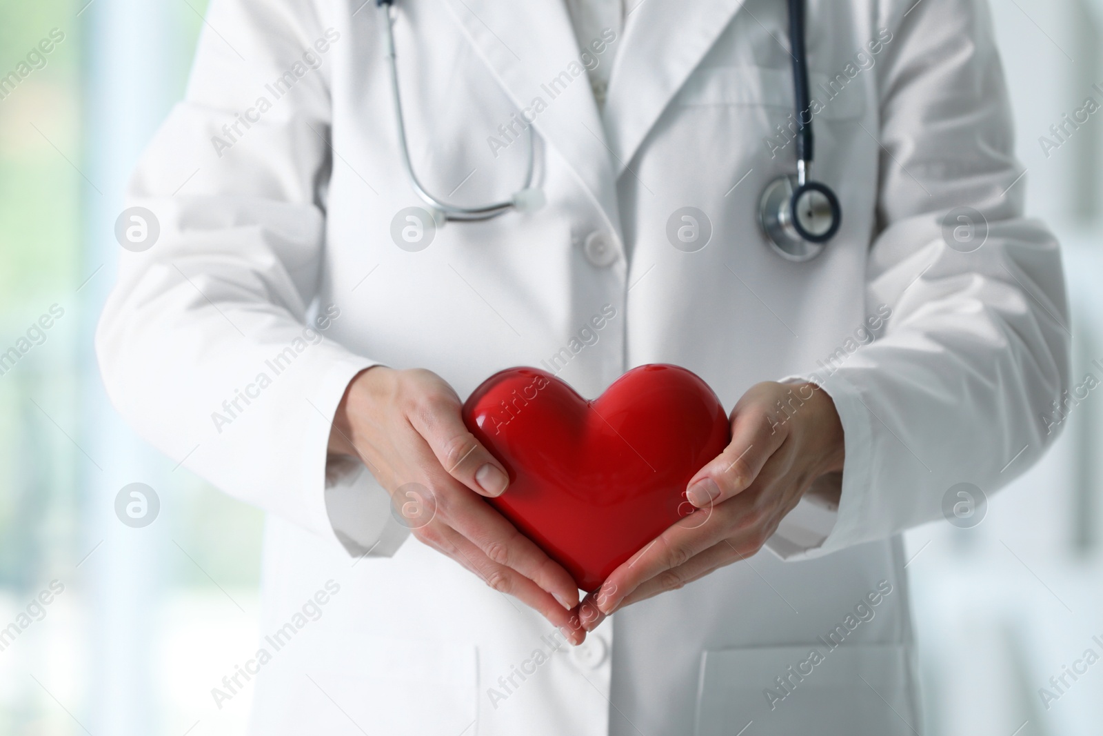 Photo of Doctor with red heart in clinic, closeup