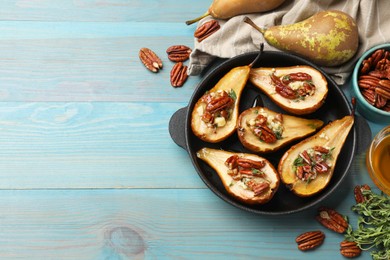 Photo of Delicious baked pears with nuts, blue cheese, thyme and honey on light blue wooden table, flat lay. Space for text