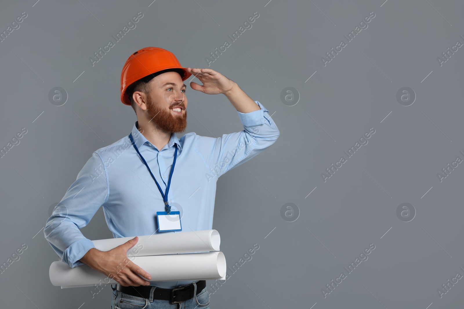 Photo of Engineer in hard hat with drafts on grey background, space for text