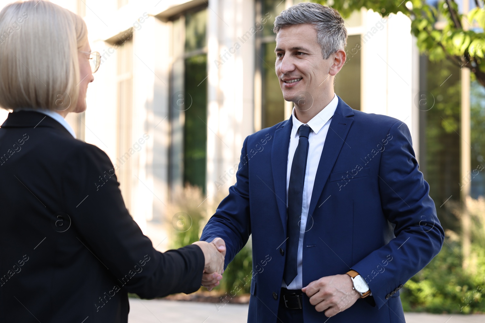 Photo of International relations. Diplomats shaking hands during meeting outdoors