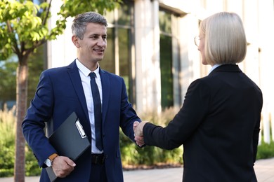 International relations. Diplomats shaking hands during meeting outdoors