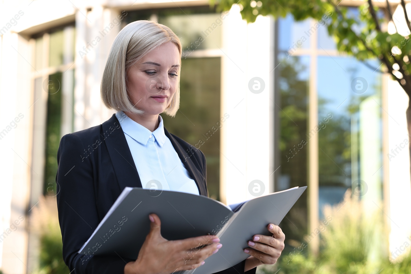 Photo of International relations. Diplomat with clipboard in suit outdoors