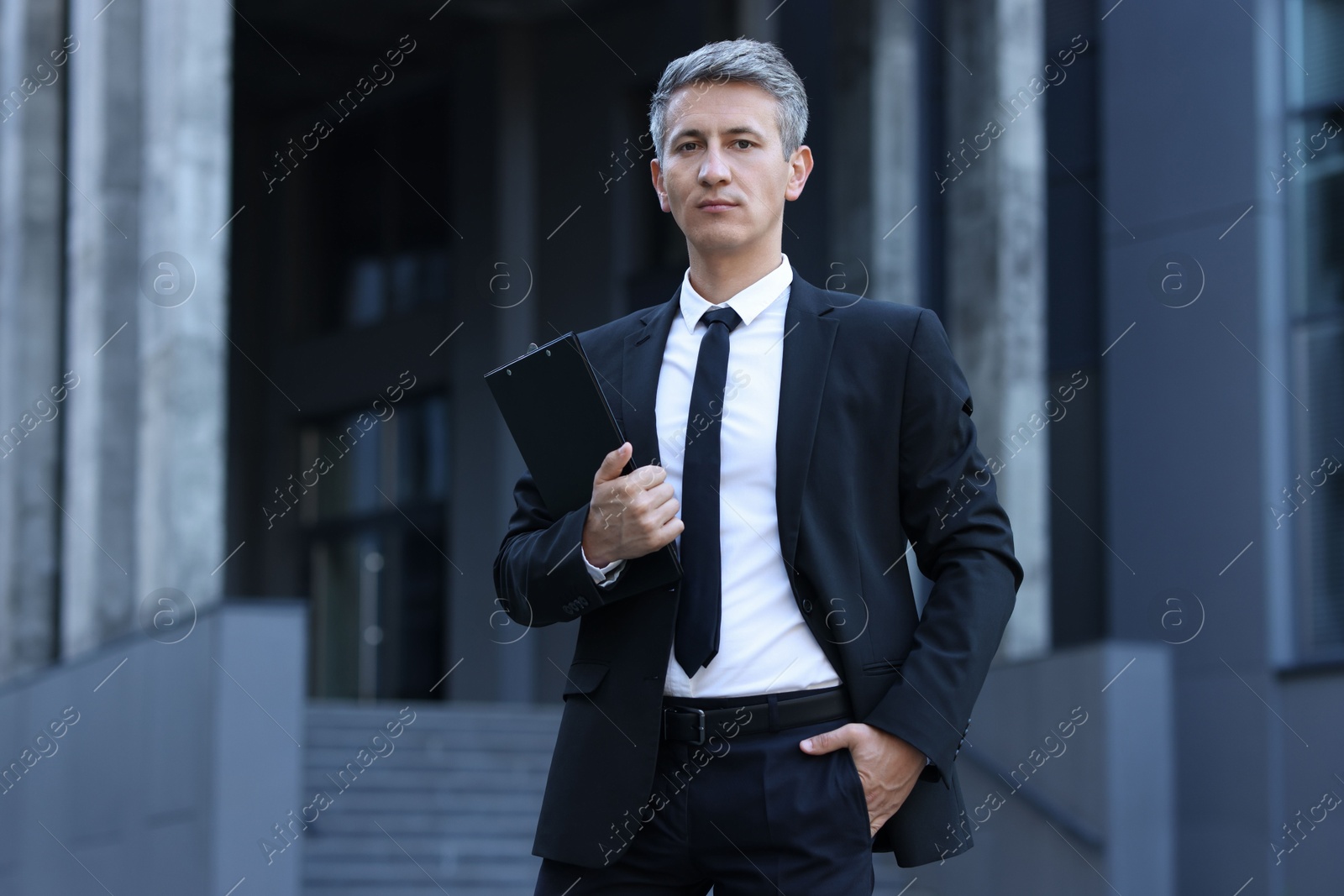 Photo of International relations. Diplomat with clipboard in suit outdoors