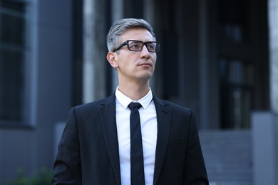 Photo of International relations. Diplomat with glasses in suit outdoors