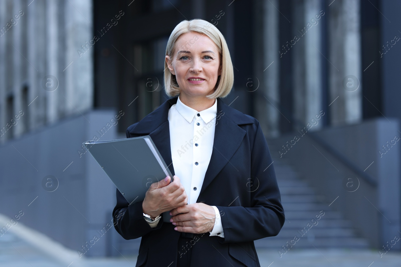 Photo of International relations. Diplomat with clipboard in suit outdoors