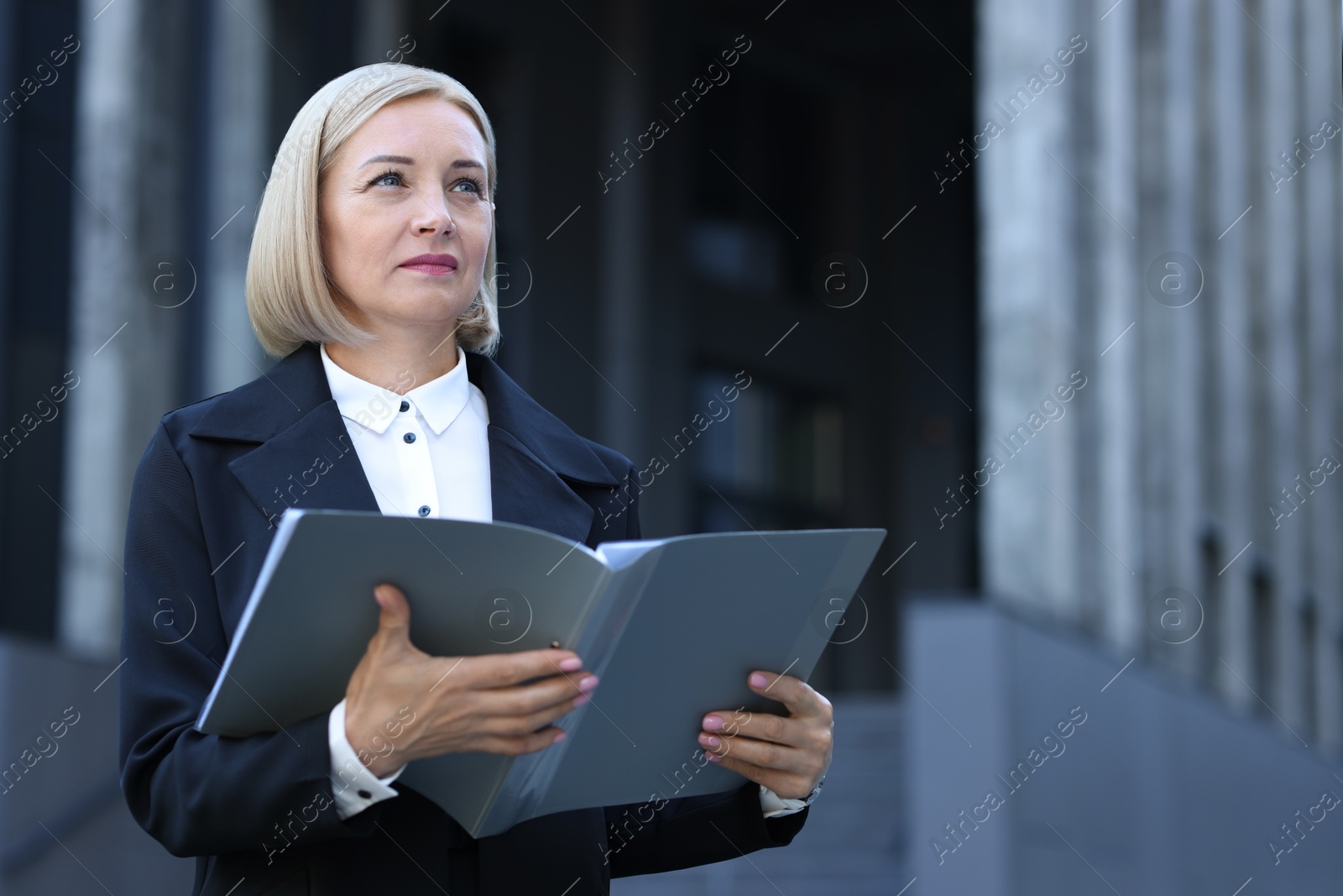 Photo of International relations. Diplomat with clipboard in suit outdoors, space for text