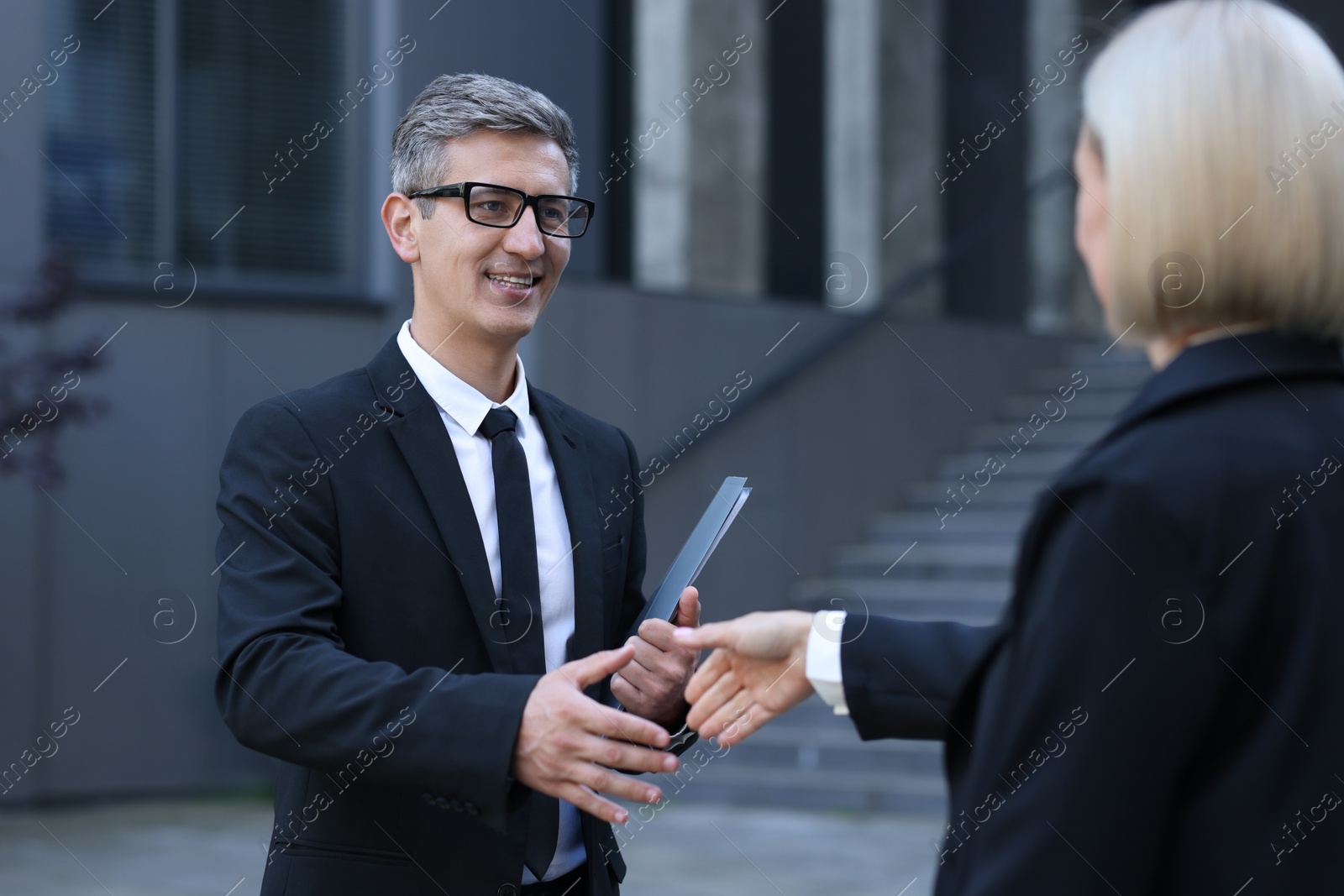 Photo of International relations. Diplomats shaking hands during meeting outdoors