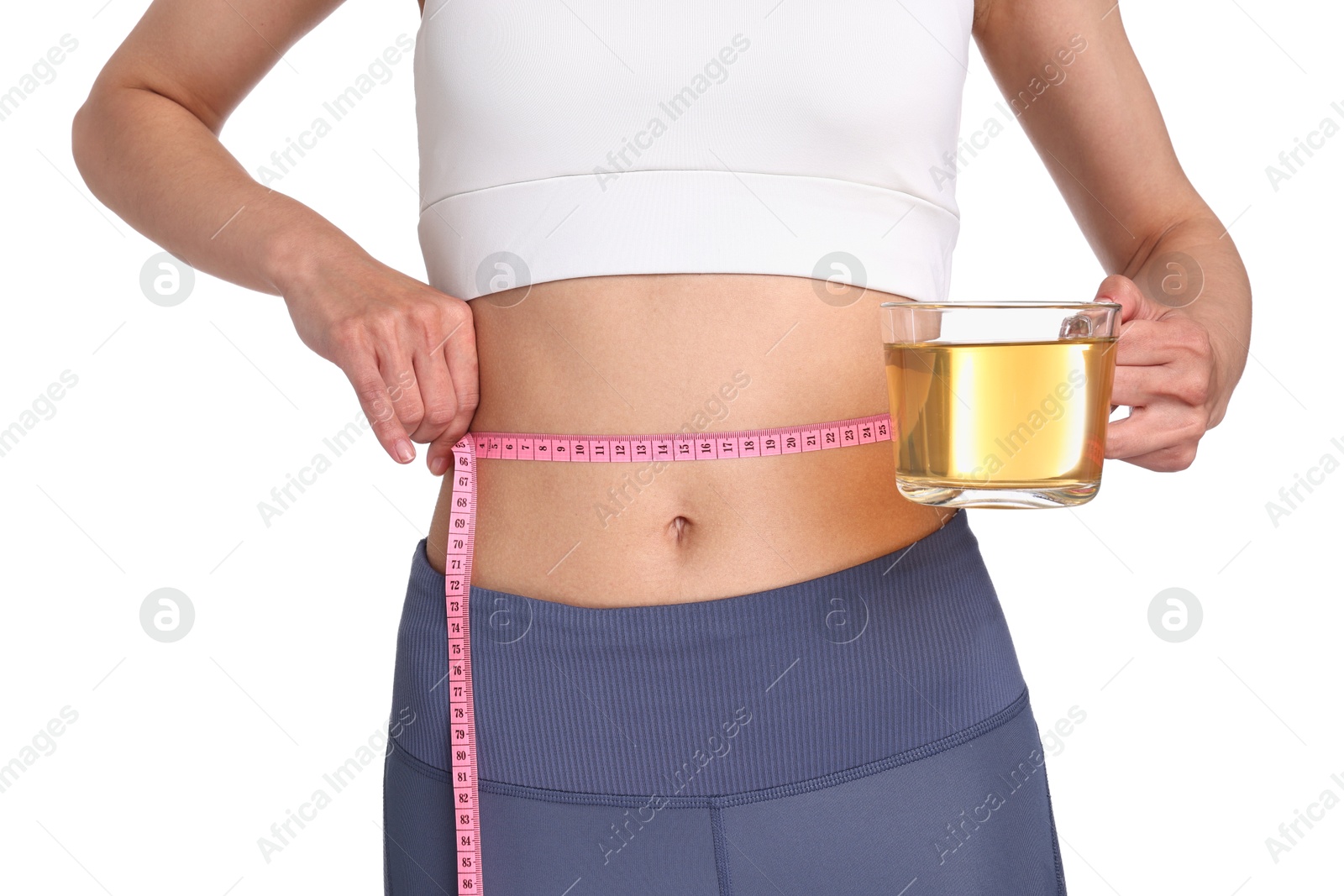 Photo of Weight loss concept. Woman with cup of diet tea and measuring tape on white background, closeup