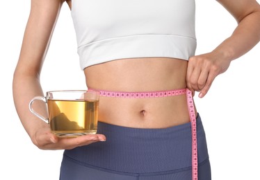 Photo of Weight loss concept. Woman with cup of diet tea and measuring tape on white background, closeup