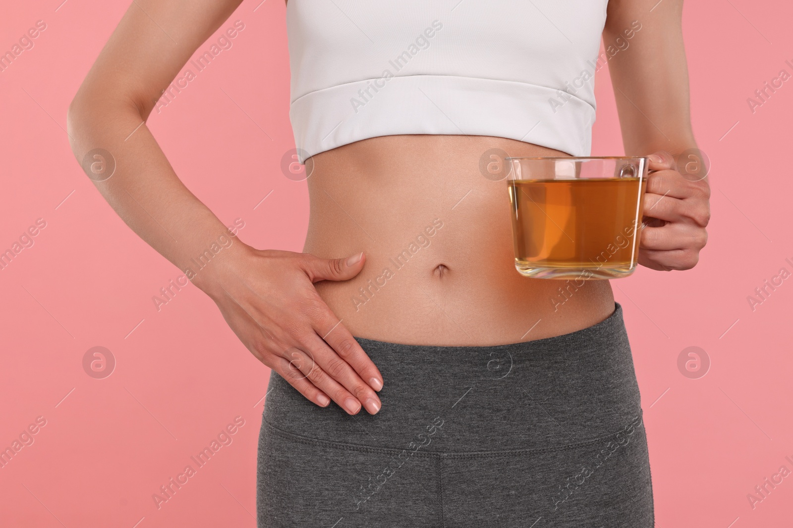 Photo of Weight loss concept. Woman with cup of diet tea on pink background, closeup