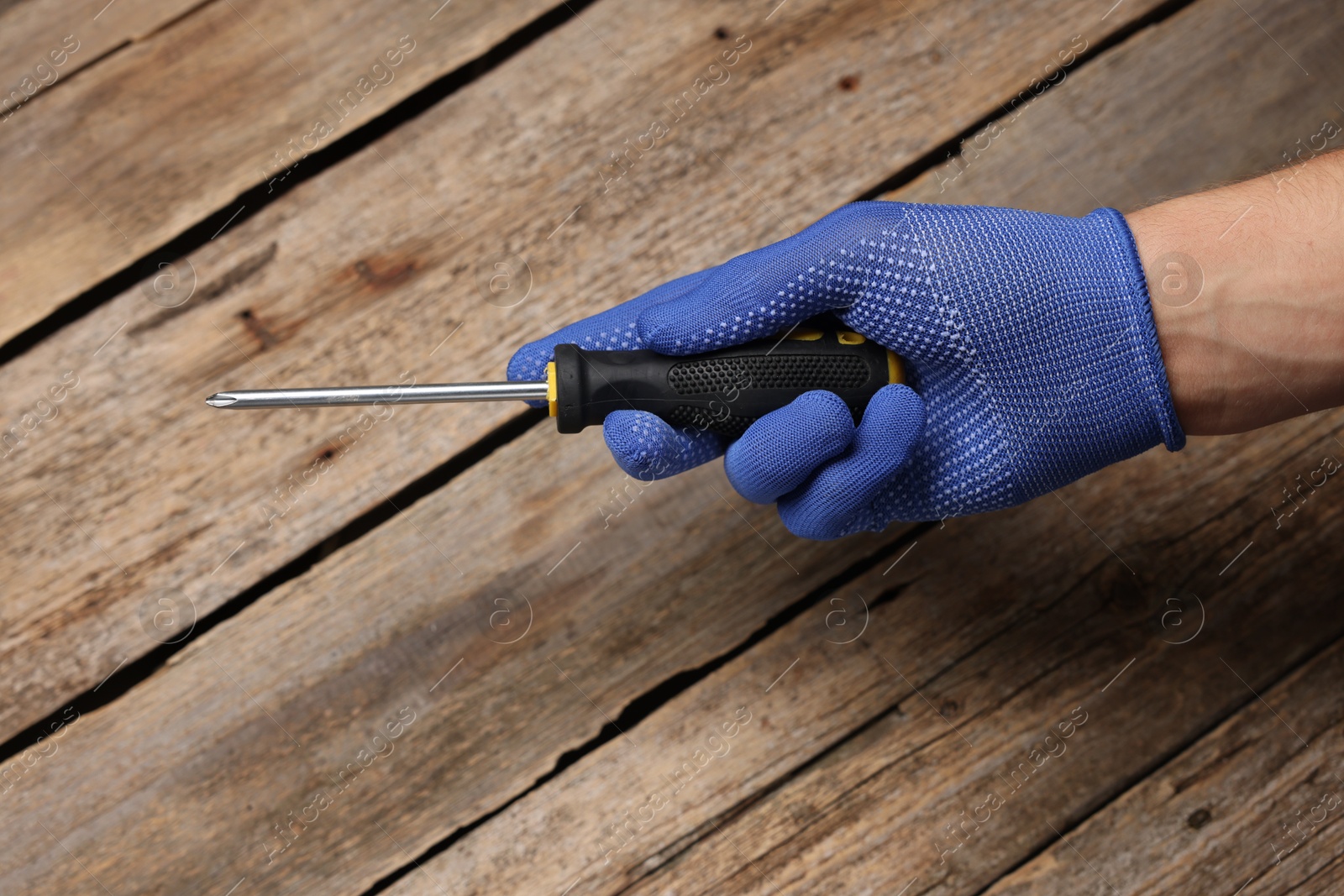 Photo of Auto mechanic with screwdriver at wooden table, closeup