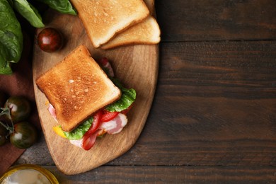 Photo of Tasty sandwiches with bacon and tomato on wooden table, flat lay. Space for text