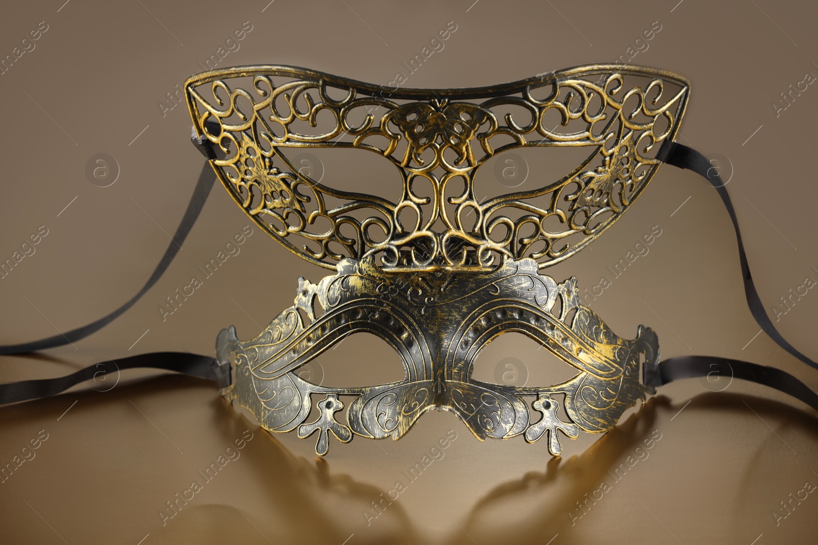 Photo of Elegant face masks on beige background. Theatrical performance