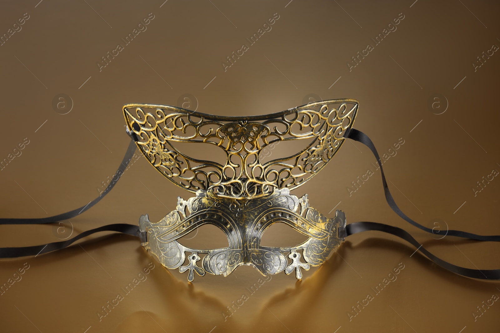 Photo of Elegant face masks on beige background. Theatrical performance