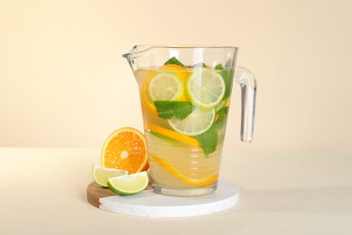 Photo of Freshly made lemonade with mint in jug on beige background