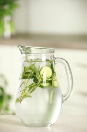 Photo of Refreshing cucumber water with rosemary in jug on white wooden table