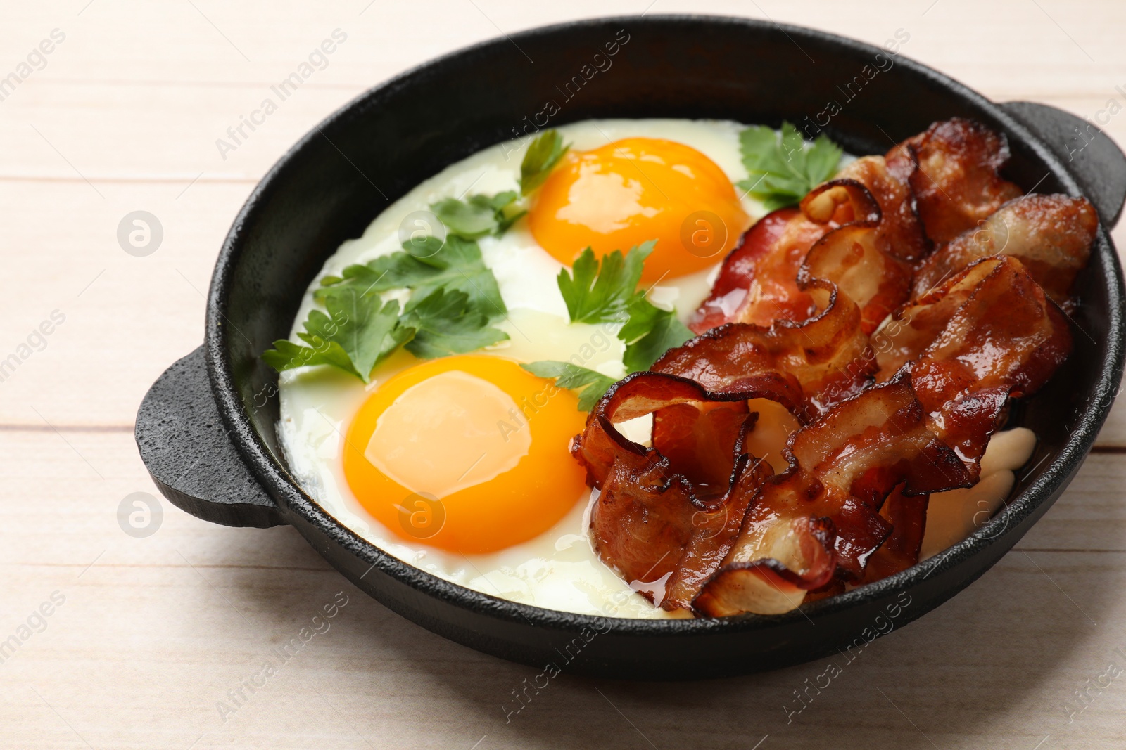 Photo of Tasty bacon, eggs and parsley on light wooden table, closeup