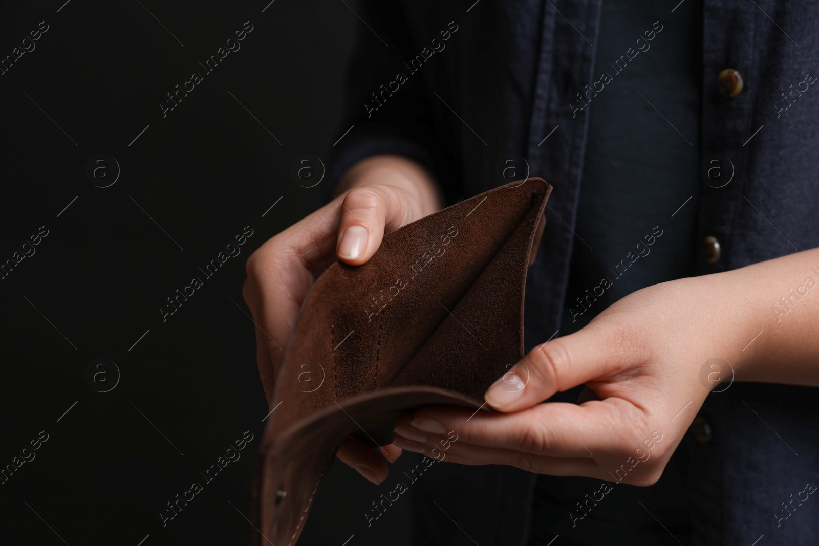 Photo of Woman with empty wallet on dark background, closeup