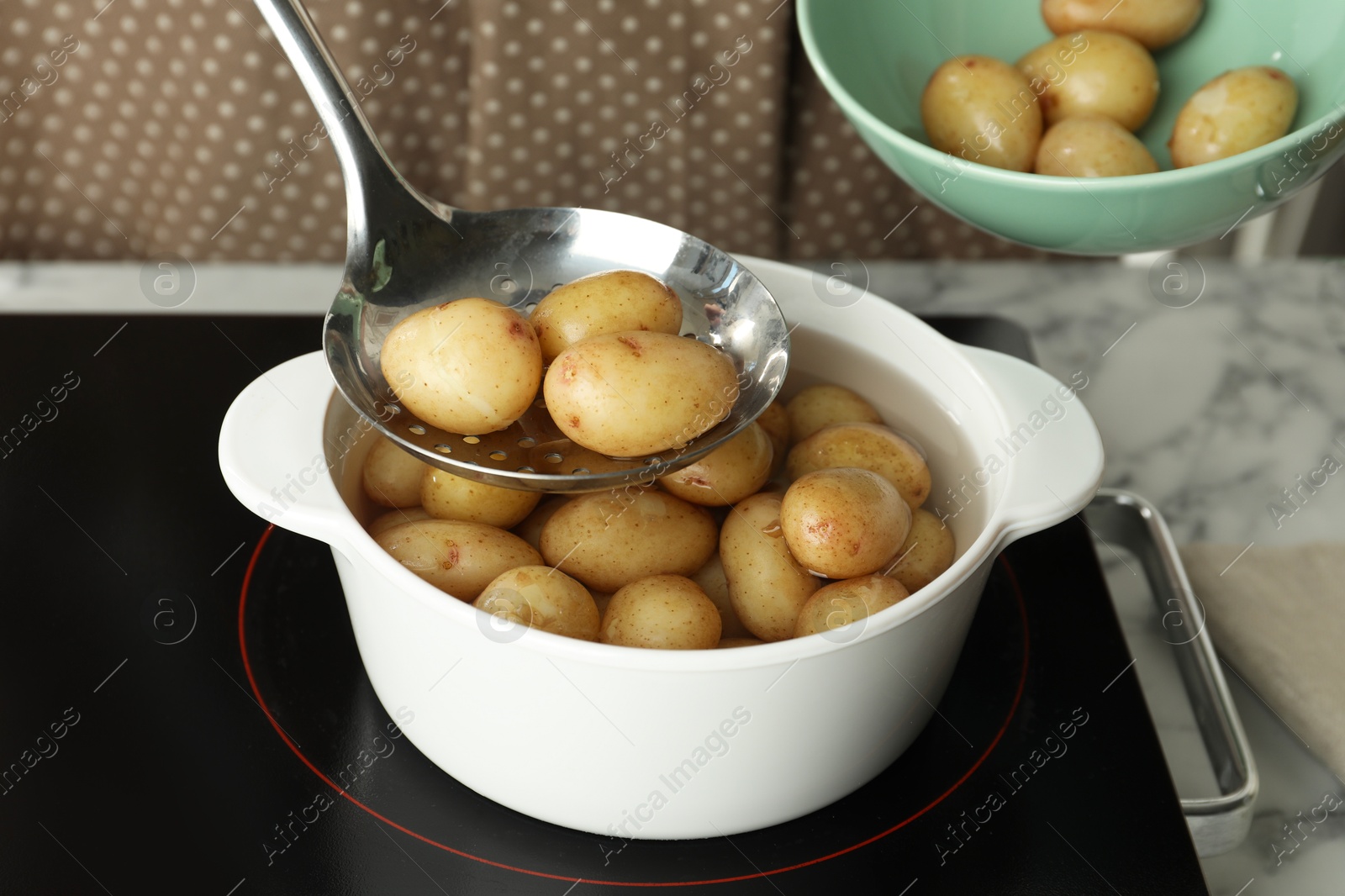 Photo of Taking potatoes from pot on stove, closeup