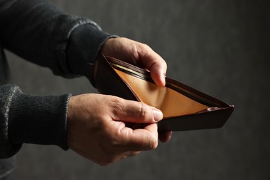 Photo of Man with empty wallet on dark background, closeup